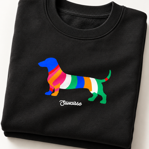 Black Saucisse Colour Me Dachshund unisex sweater folded to show the colourful striped dachshund front print and white Saucisse signature.