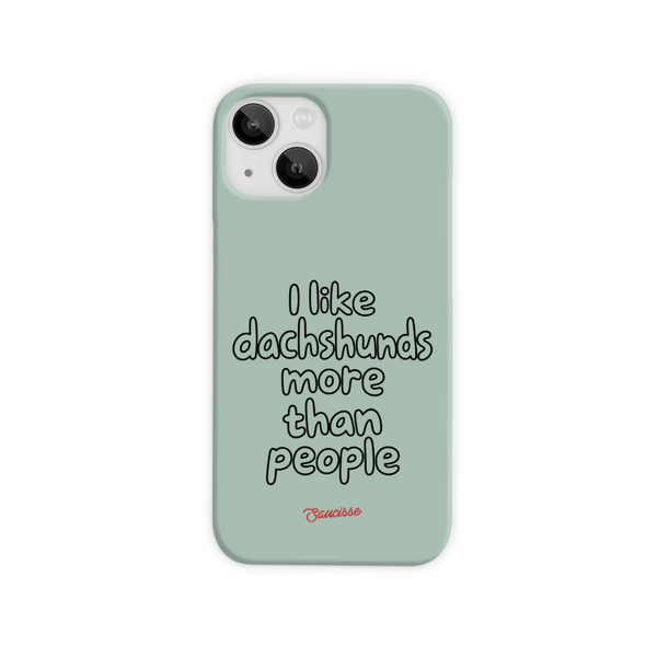 Saucisse sage-green phone case for iPhone 15, with “I like dachshunds more than people” lettering and a red signature.