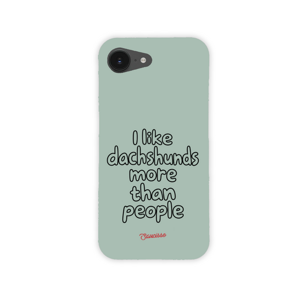 Saucisse sage-green phone case for iPhone 17e, with “I like dachshunds more than people” lettering and a red signature.