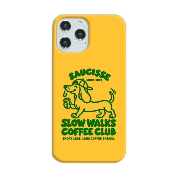 Saucisse yellow case with green dachshund artwork and Slow Walks Coffee Club lettering, showing the printed back and model-specific camera opening.
