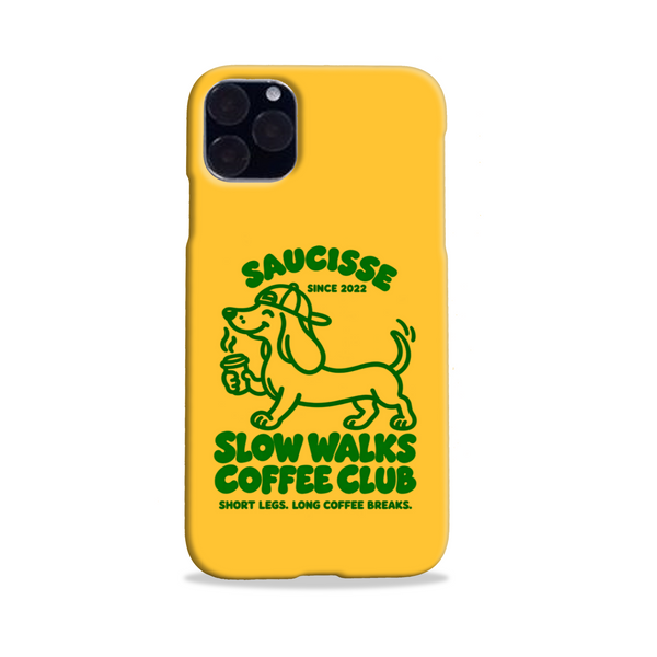 Saucisse yellow case with green dachshund artwork and Slow Walks Coffee Club lettering, showing the printed back and model-specific camera opening.