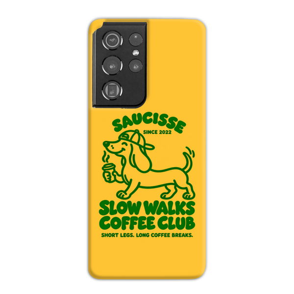 Saucisse yellow case with green dachshund artwork and Slow Walks Coffee Club lettering, showing the printed back and model-specific camera opening.