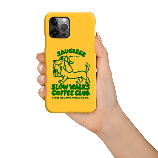 Saucisse yellow case with green dachshund artwork and Slow Walks Coffee Club lettering, held against a white background.
