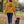 Woman wearing the Curcuma Saucisse Manchester England hoodie, showing its back print while walking a long-haired dachshund in an autumn park.