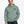 Man wearing the Saucisse Manchester England unisex hoodie in Jade Green, showing the small black Dachshund Apparel chest print.
