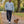 Man wearing the Saucisse Manchester England unisex sweater in Aquamarine while walking a dachshund in a leafy park