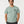 Studio view of a male model wearing the Saucisse Dachshund Apparel Manchester England T-shirt in Aloe