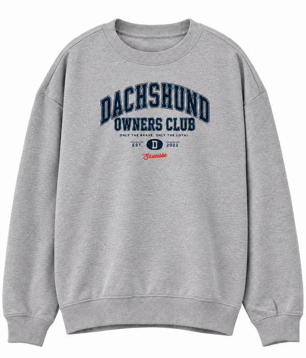 Front of the Saucisse Dachshund Owners Club 2026 unisex sweater in Moon Heather Grey, with a navy varsity design and red Saucisse signature