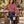 A woman wearing the Antique Rose Saucisse Dachshunds & Wine hoodie in a British pub garden, with a dachshund at her feet.