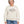 Woman with short grey hair wearing the Saucisse Dachshunds & Wine sweater in Ivory, styled with jeans in a white studio.