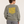 Woman wearing the Saucisse Long Walk Sundays Almond Green sweater in a warm neutral studio, rear view showing the yellow print following the fabric