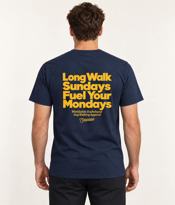 Man wearing the Saucisse Long Walk Sundays French Navy T-shirt in a warm neutral studio, rear view showing the centred yellow design