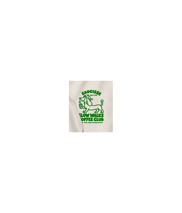 Close-up of the green Slow Walks Coffee Club chest print on the Ivory Saucisse hoodie, showing the fabric texture