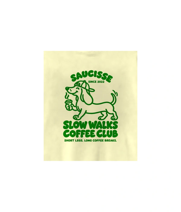 Close-up of the green Slow Walks Coffee Club back print on the Lemon Citrus Saucisse sweater, showing the fabric texture