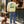 Saucisse Slow Walks Coffee Club unisex sweater in Lemon Citrus, rear coffee-stop lifestyle view with green back print and a dachshund on a lead