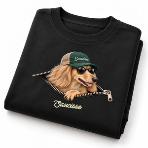 Folded Saucisse Unzipped long-haired unisex sweater in Black, showing the long-haired dachshund and printed zip artwork.