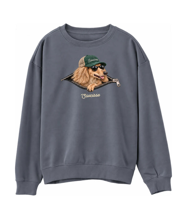 Saucisse Unzipped long-haired unisex sweater in Mineral Grey, front view showing a long-haired dachshund in a green cap and sunglasses emerging from a printed zip.