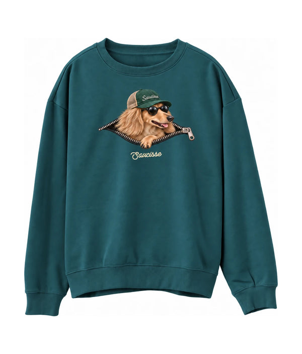 Saucisse Unzipped long-haired unisex sweater in Peacock Green, front view showing a long-haired dachshund in a green cap and sunglasses emerging from a printed zip.