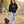 Woman wearing the Black Saucisse Unzipped Short Haired unisex hoodie walking a dachshund along an autumn path, with the dachshund front print visible.