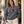 Woman wearing the Mineral Grey Saucisse Unzipped Short Haired unisex sweater outside a café holding a takeaway coffee, with the dachshund front print visible.