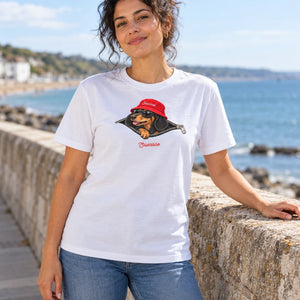 Woman wearing the White Saucisse Unzipped Short Haired unisex T-shirt beside the sea, with the dachshund front print visible.