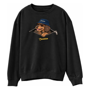 Front of the Saucisse Unzipped wire-haired unisex sweater in Black, with a navy-hat dachshund, printed silver zip and gold Saucisse signature.