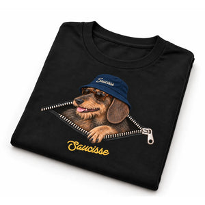 Folded Saucisse Unzipped wire-haired unisex T-shirt in Black, showing the dachshund, navy bucket hat and printed zip artwork.
