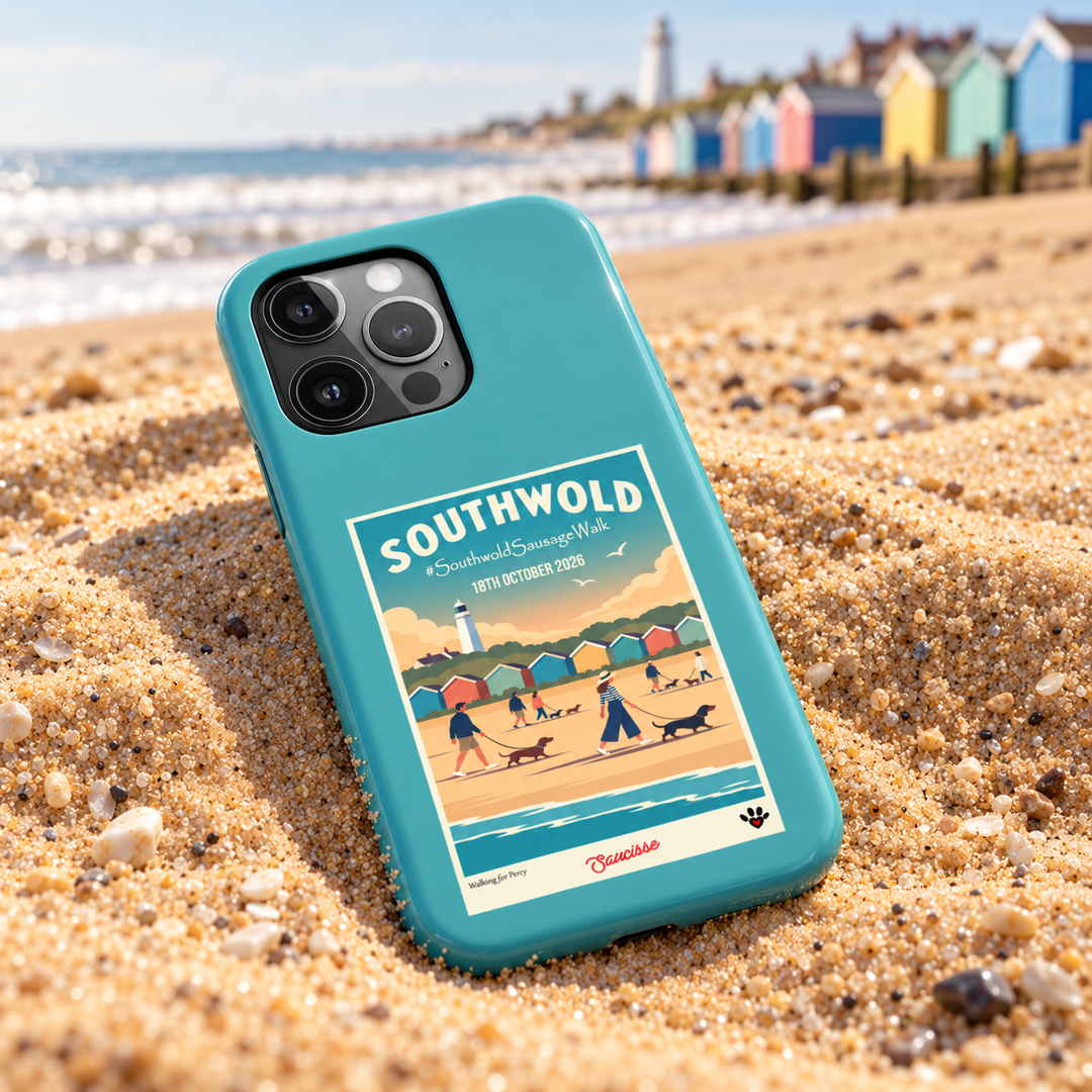 Teal Southwold Sausage Dog Walk 2026 phone case on sand beside British beach huts