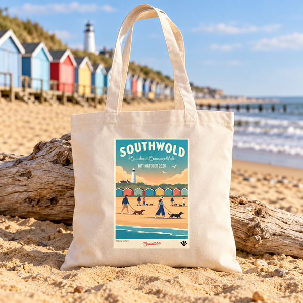 Natural Raw Southwold Sausage Dog Walk 2026 tote bag on a sandy British beach beside beach huts